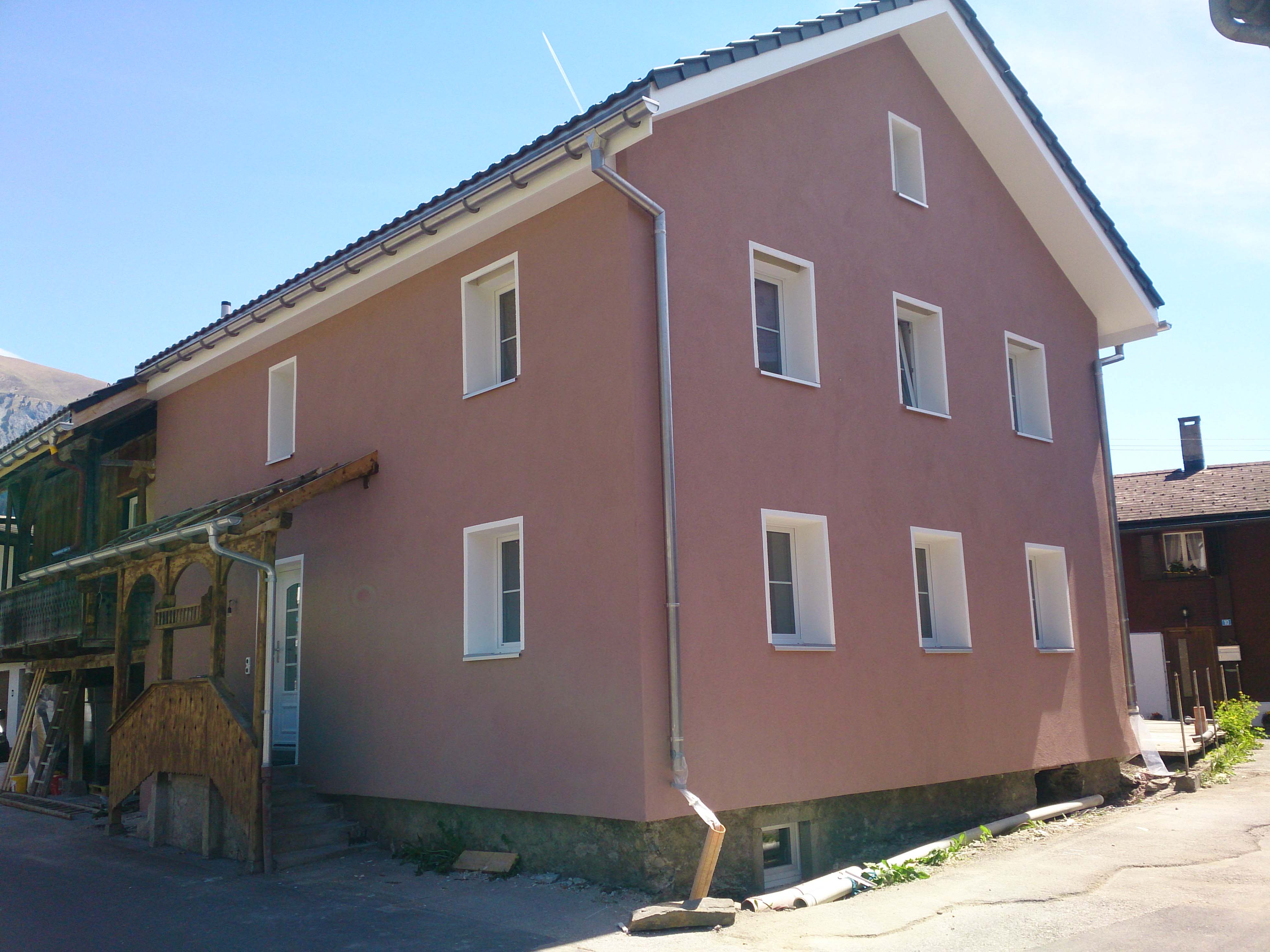 Rosa renovierte Fassade eines Bündner Wohnhauses